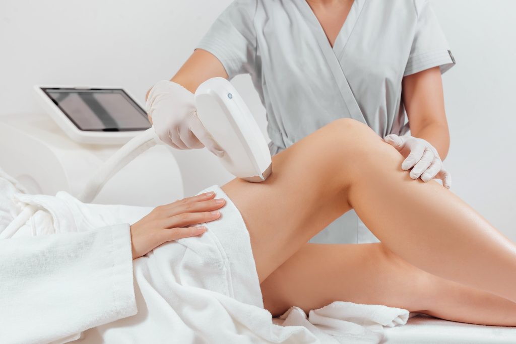 Young woman making body hair removal laser depilation